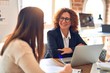 © Krakenimages.com - Two beautiful businesswomen smiling happy and confident. Sitting with smile on face working together using laptop at the office