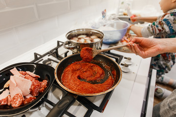 Cooking tomato paste and pizza in the kitchen