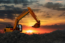 Excavators Are Digging The Soil In The Construction Site On The  Sunset  Background
