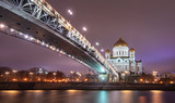 Fototapeta  - The Cathedral of Christ the Saviour or Savior and Patriarchal pedestrian bridge with night illumination in the evening in Moscow, Russia. Russian Orthodox church on the Moskva river