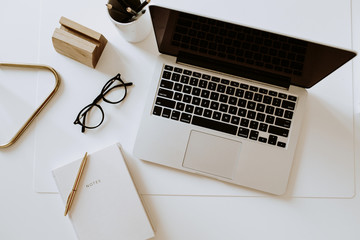 Wall Mural - Home office desk workspace with laptop, notebook, glasses on white table. Flat lay, top view minimal women's, girl boss background.