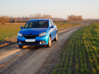 Belarus blue car in a field in spring at sunrise