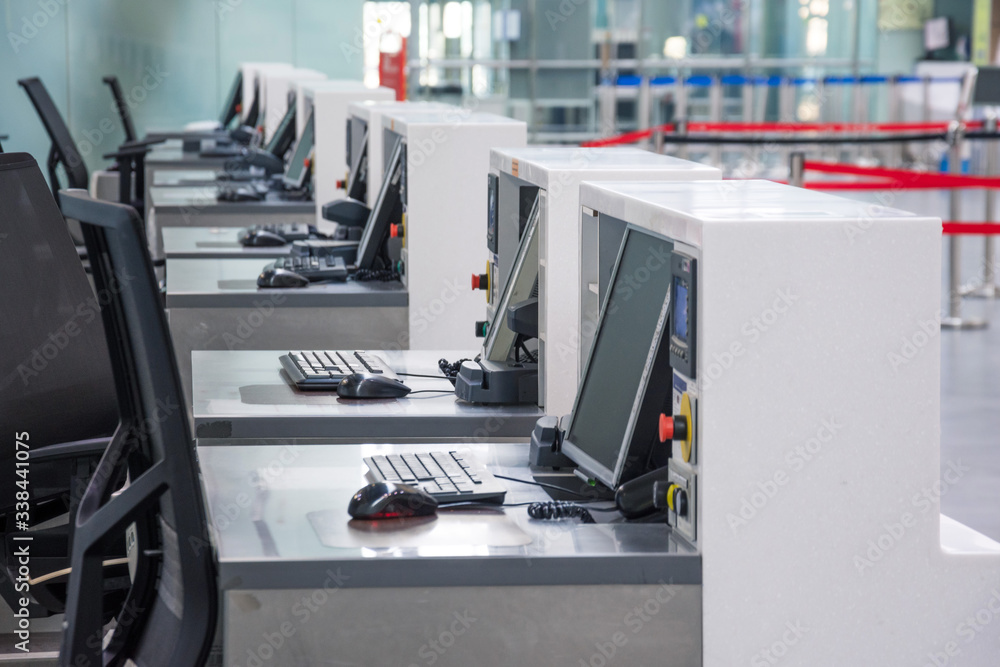 Row of empty check-in desks with computer monitors at the airport ...