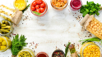 Background of food stocks in glass jars. Pickled vegetables and mushrooms. Top view.