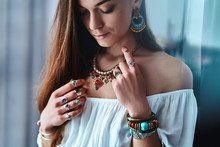 Stylish Sensual Boho Woman Wearing White Blouse With Big Earrings, Gold Necklace, Bracelets And Silver Rings With Stone. Fashionable Indian Gypsy Bohemian Outfit With Jewelry Details