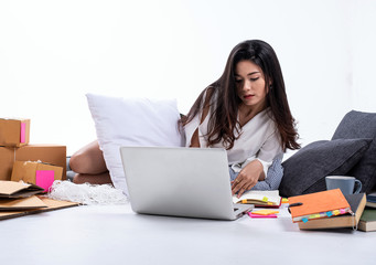 Beautiful lady laying down beside post box,using laptop and book for record data of selling online,work at home,e-commerce