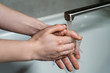 © filin174 - Good hygiene during the coronavirus pandemic. Woman washes hands in hot running water with soap