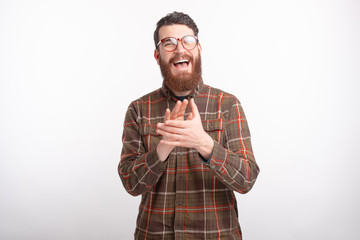 Portrait of young man applauding over white background and smiling, cheerful hipster guy