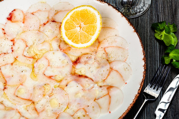 Wall Mural - Octopus carpaccio with lemon on white plate.