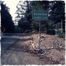 Bicycle Leaning Against County Line Signboard