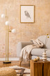 © FollowTheFlow - Modern concept of living room interior with gold lamp, design grey sofa, wooden cube, rattan pouf, mock up picture frame, dried flowers in vase, carpet and elegant accessories in home decor.