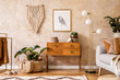 © FollowTheFlow - Modern retro composition of living room with wooden vintage commode, grey sofa, gold lamp, macrame, carpet, pillows, gold mock up poster frame, plants, decoration and personal accessories.