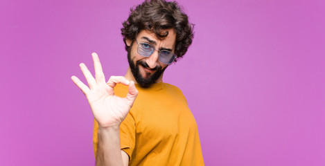 young crazy cool man feeling happy, relaxed and satisfied, showing approval with okay gesture, smili