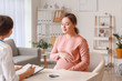 © Pixel-Shot - Young pregnant woman visiting doctor in clinic