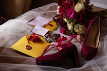 Wedding Accessories: A Bride’s Bouquet Of Roses, Peonies And Hydrangeas, Wedding Rings On A Stone, A Ring And Earrings With Diamonds, Women's Shoes, Invitation And Yellow Envelopes With A Red Wax Seal