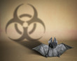 Viral pandemic concept. covid-19. Origami bat figure that casts a shadow on the biohazard sign.