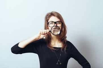 funny young woman with a magnifying glass