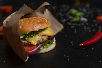 Fresh burger cooked on a barbecue outdoors in kraft paper. Cookout american barbecue food.