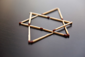 Magen David, Israel word from matches. Magen David, Israel from matches on a black wood. Concept of matches magen David, Israel.