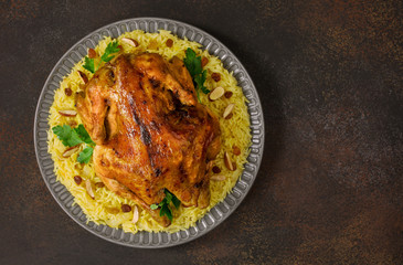 Canvas Print - Kabsa - arabian dish made of long grain basmati rice, whole chicken, onion, spices: cardamom, saffron, cinnamon, bay leaves.  Decorated with almonds and raisins. Saudi Arabia food.