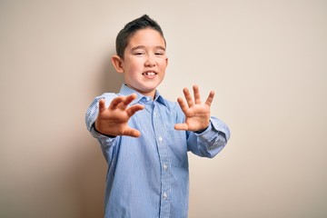 Sticker - Young little boy kid wearing elegant shirt standing over isolated background afraid and terrified with fear expression stop gesture with hands, shouting in shock. Panic concept.