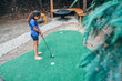 Girl playing put-put golf in backyard of home 
