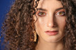 © Pixel-Shot - Young woman with beautiful curly hair on color background, closeup