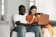 © SHOTPRIME STUDIO - young couple sitting on sofa with laptop