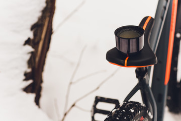 Man pours tea from a thermos. Winter forest. Close-up.