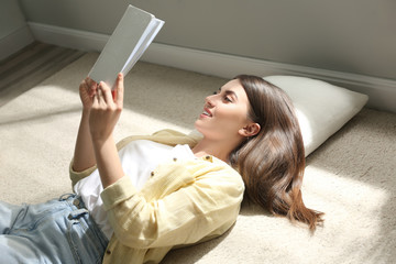 Canvas Print - Beautiful young woman reading book at home