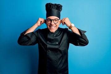 Poster - Middle age handsome grey-haired chef man wearing cooker uniform and hat Smiling pulling ears with fingers, funny gesture. Audition problem