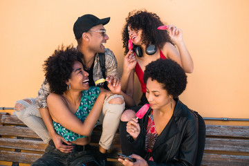 Wall Mural - Multi-ethnic group of friends enjoying summertime while eating ice cream.