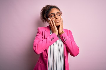 Canvas Print - Beautiful african american businesswoman wearing jacket and glasses over pink background Tired hands covering face, depression and sadness, upset and irritated for problem