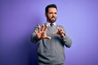 © Krakenimages.com - Handsome businessman with beard wearing casual tie standing over purple background disgusted expression, displeased and fearful doing disgust face because aversion reaction. With hands raised
