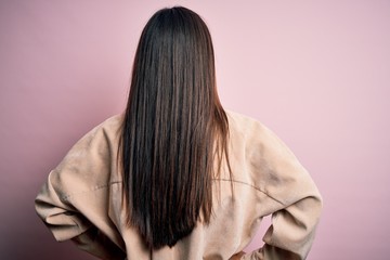 Poster - Young beautiful asian woman wearing casual shirt standing over pink background standing backwards looking away with arms on body