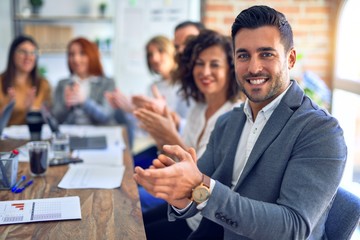 Group of business workers smiling happy and confident. Working together with smile on face looking at the camera applauding at the office