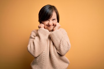 Sticker - Young down syndrome woman wearing casual sweater over yellow background covering ears with fingers with annoyed expression for the noise of loud music. Deaf concept.