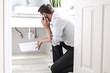 © RightFramePhotoVideo - Man Calling Plumber In Front Of Water Leaking From Sink Pipe