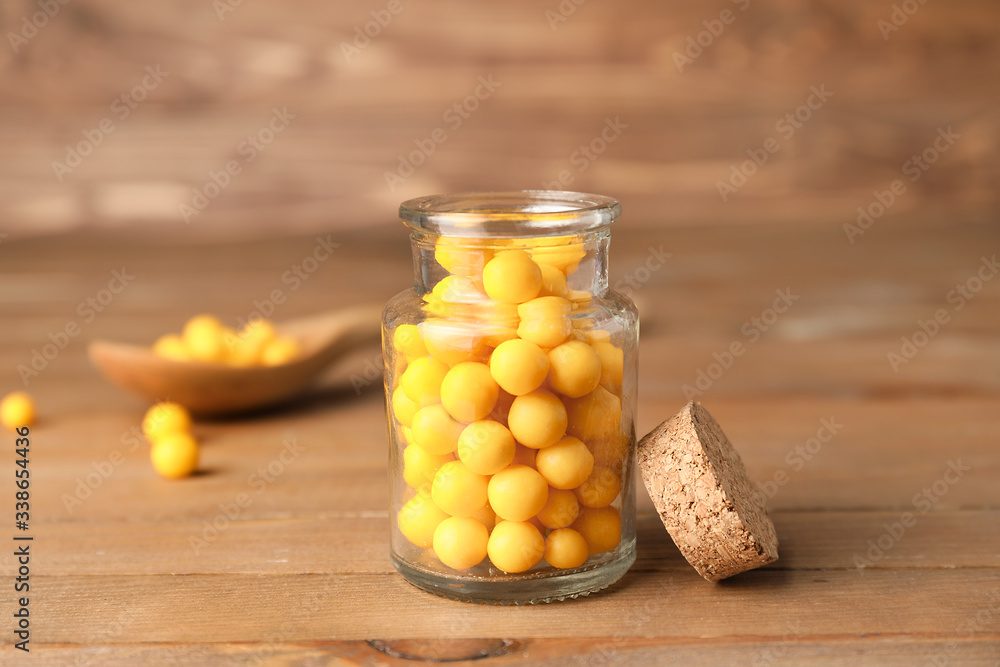 Bottle with pills on wooden background