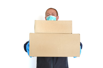 Courier with parcels. Home delivery. Online purchases.Food delivery on isolation.Shopping during quarantine.A man in a medical mask and blue gloves with cardboard boxes on a white background