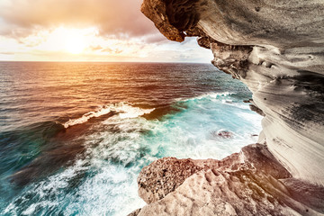 Wall Mural - Wonderful sunset over the sea with waves. Amazing view from the rocky coast at Bondi Beach in Sydney Australia.
