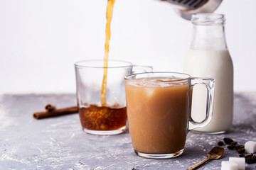 Wall Mural - Cooled coffee with milk, cinnamon sticks, coffee beans, sugar, spoon on the table.