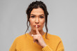 © Syda Productions - silence, confidentiality and people concept - portrait of young woman with pierced nose making hush gesture over grey background