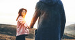 © Strelciuc - Lovely woman with eyeglasses and hat holding the hand of her lover and posing in a field