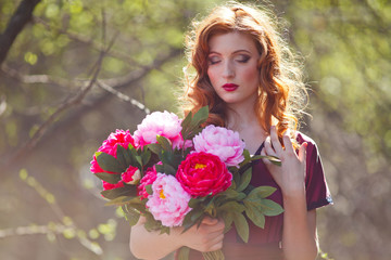 Wall Mural - red-haired girl in a burgundy dress walks in the forest