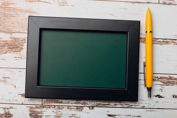 Clean vintage chalk board on a wooden table.