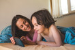 © zhukovvvlad - A boy with his mother lies in bed and looks at the smartphone.