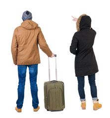 Poster - young couple in winter jacket traveling with suitcas.