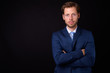 © Ranta Images - Portrait of bearded businessman in suit with arms crossed