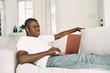 © SHOTPRIME STUDIO - man sitting on sofa with laptop